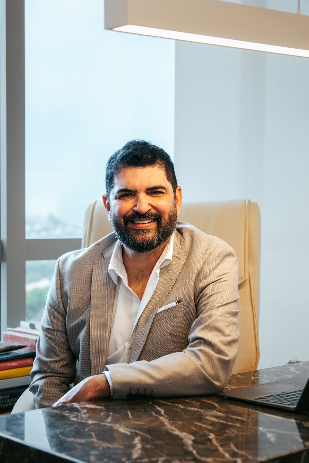 Dr. Charles Farias sentado no consultório da Perfektion